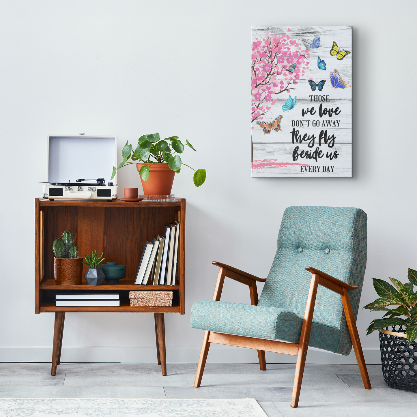 Memorial wall art with pink blossoms and butterflies, comforting sympathy quote above mid-century modern armchair and wooden .