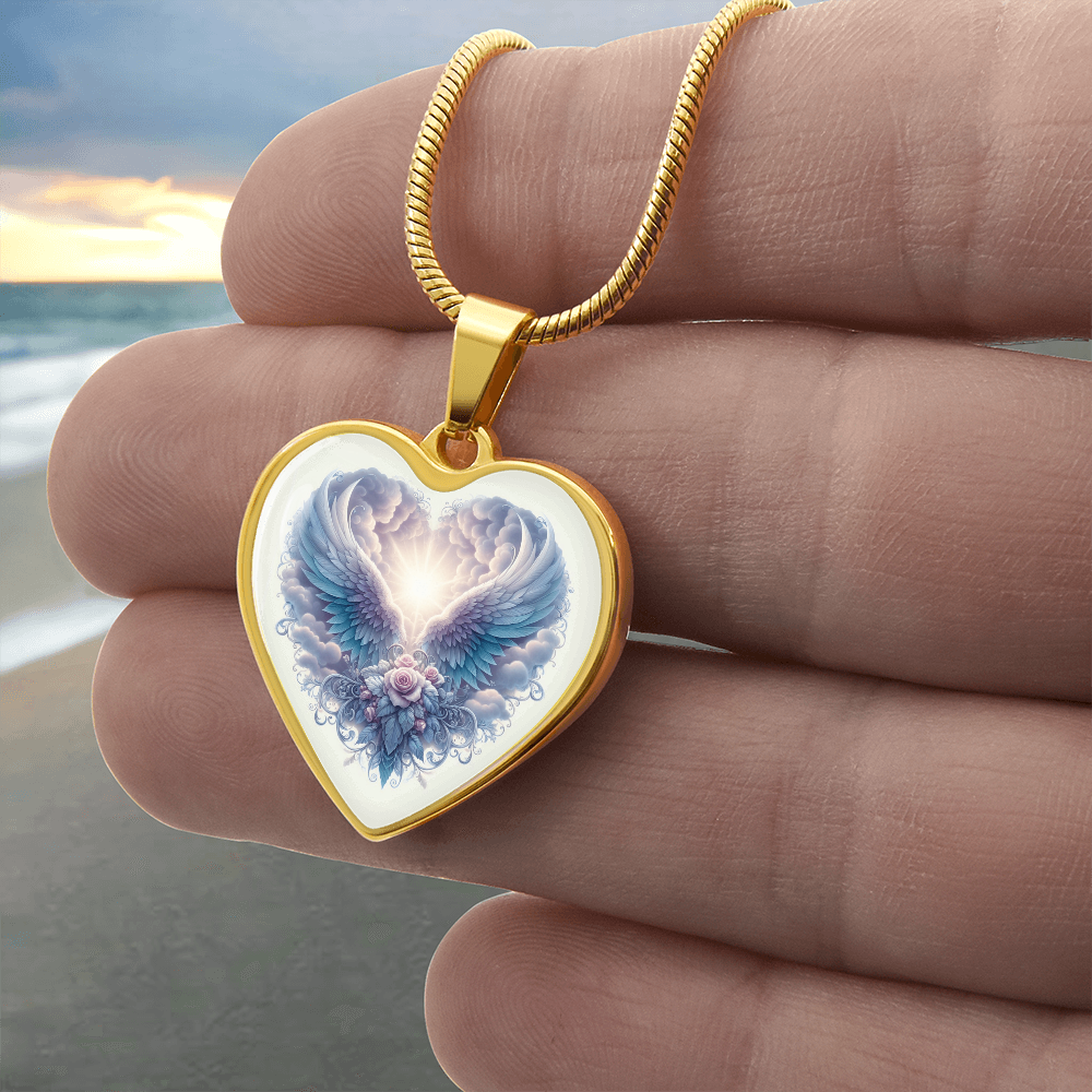 Gold heart-shaped necklace pendant with angel wings graphic and light center on snake chain.
