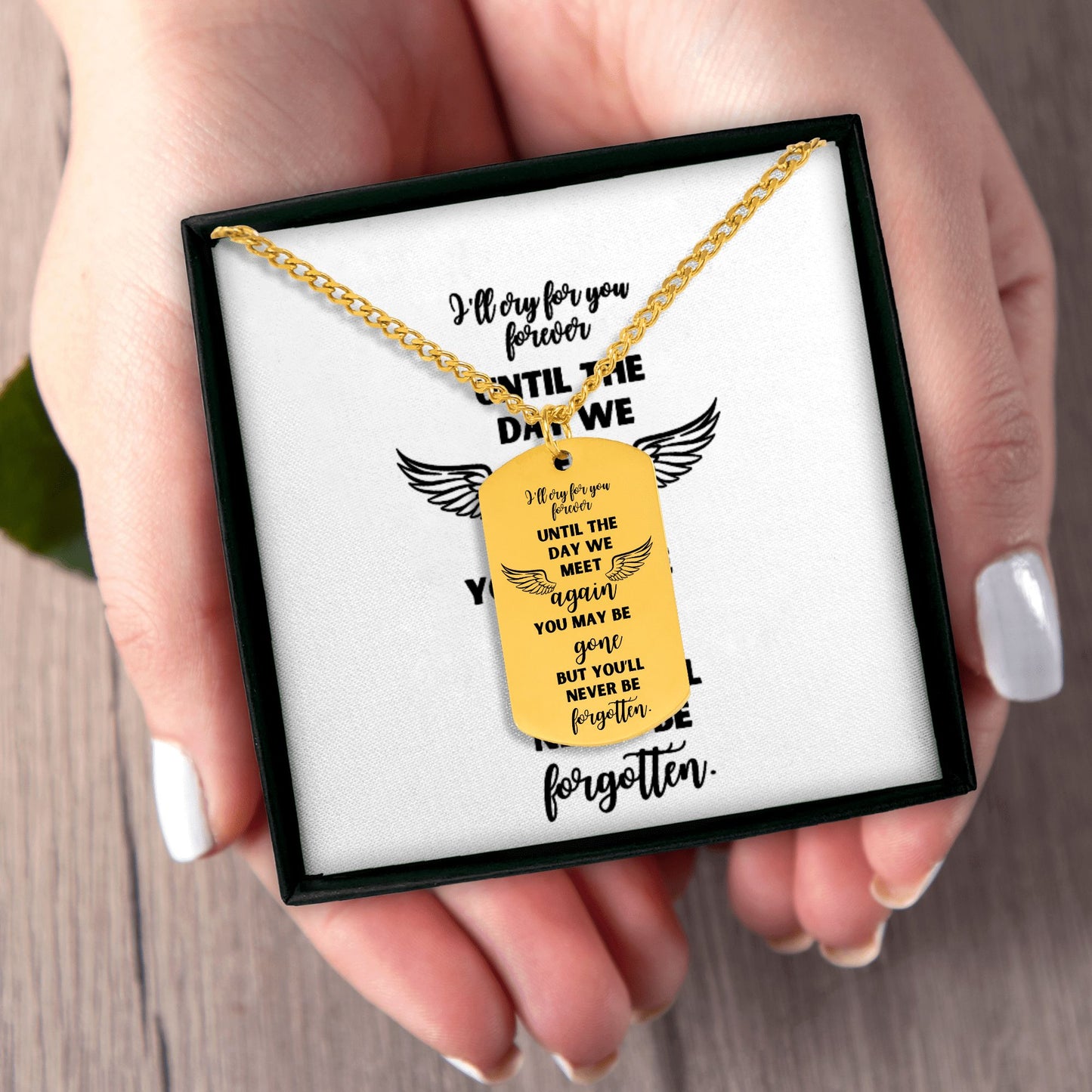 18k gold plated memorial dog tag necklace with engraved sentimental message and wings design in black gift box held in hands.