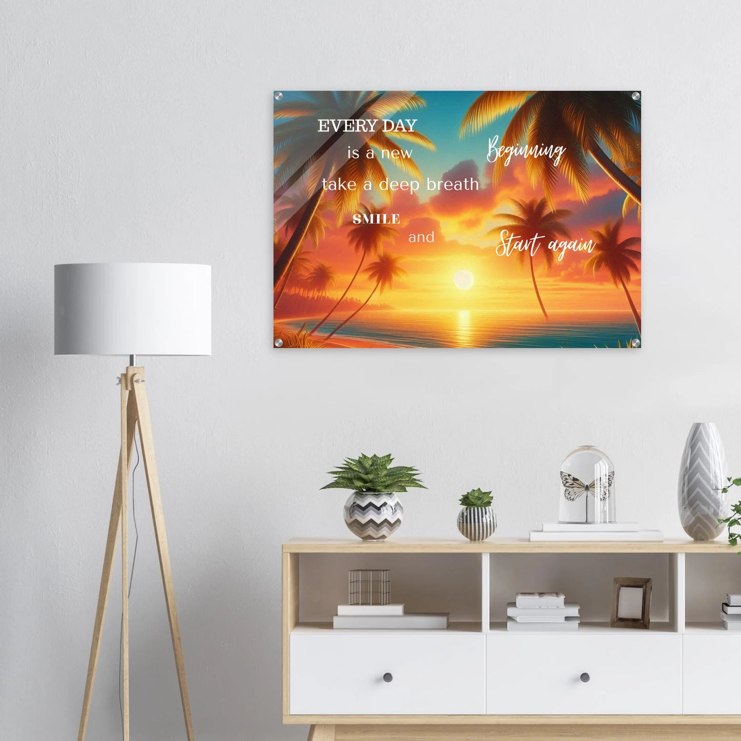 Decorative wall art with motivational quote and sunset design in a room with a lamp and shelves.