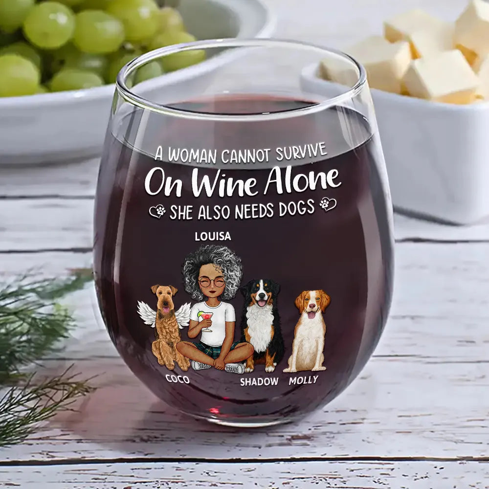 Stemless wine glass filled with red wine, personalized with a woman, three dogs, and text on the glass.