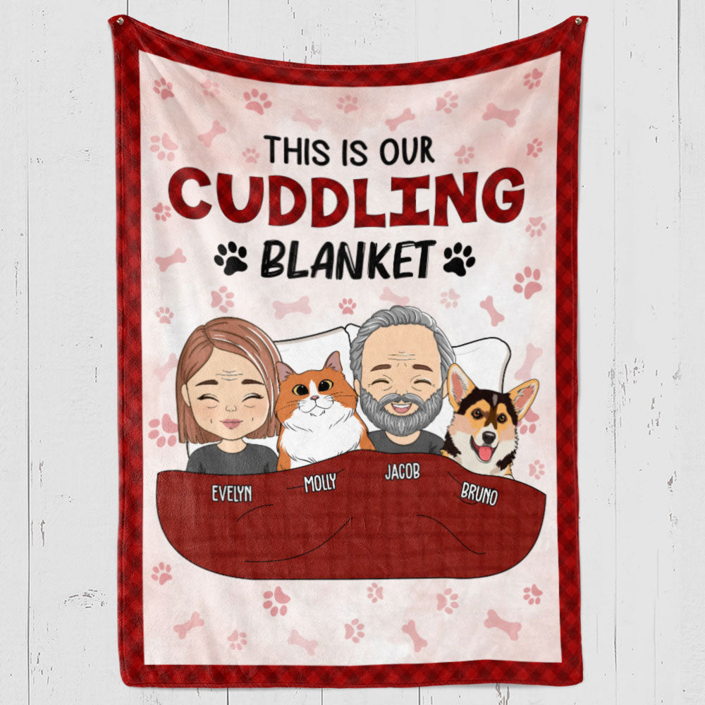 Red and white fleece blanket with cartoon couple and two dogs, personalized names, and "This is our Cuddling Blanket" text.