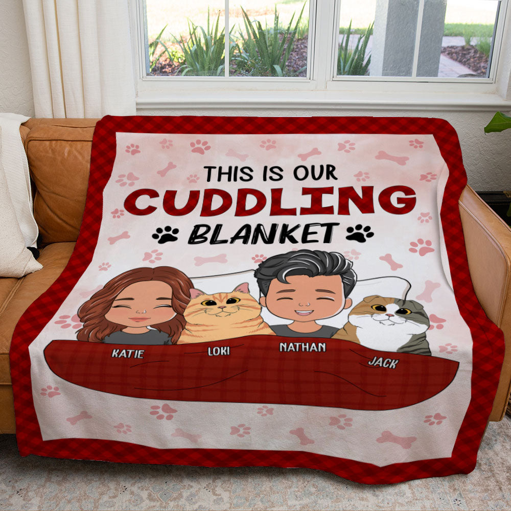 Red and pink fleece blanket featuring cartoon family portraits and pets, personalized with names and the phrase "This is our