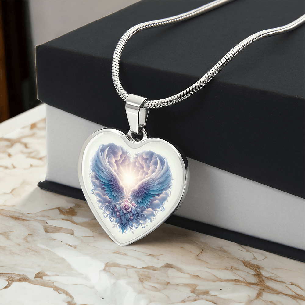 Silver heart pendant necklace with angel wings graphic and glowing center on snake chain.