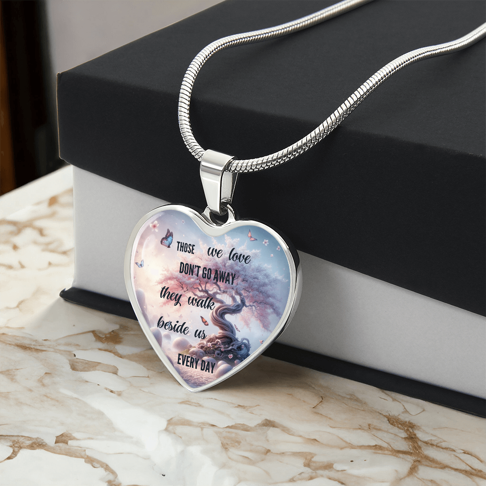 Silver heart-shaped pendant necklace with "Those we love don't go away" text and scenic river design.
