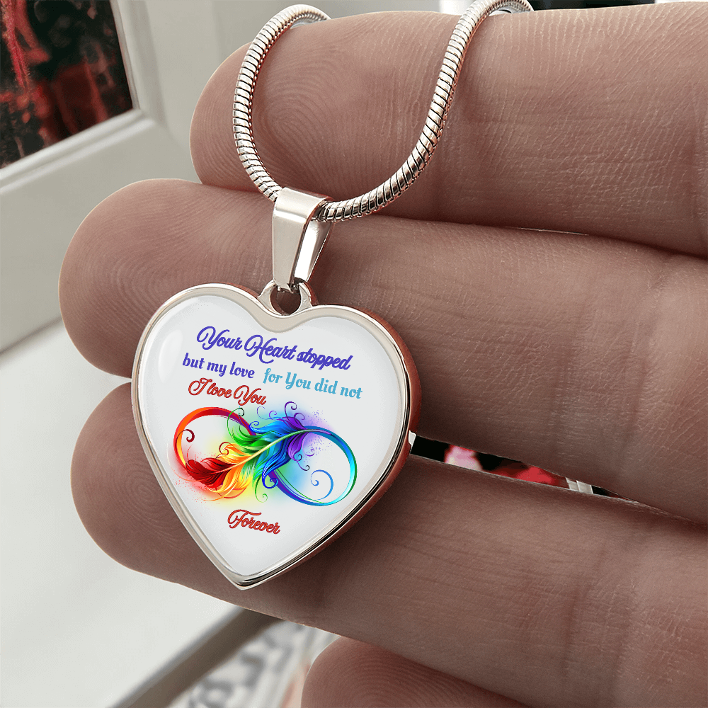 Silver heart pendant necklace with colorful infinity design and “Your heart stopped but my love for you did not” text.