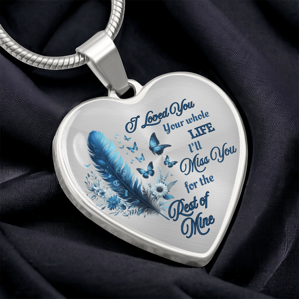 Silver heart-shaped pendant necklace with blue feather and engraved sentimental message.