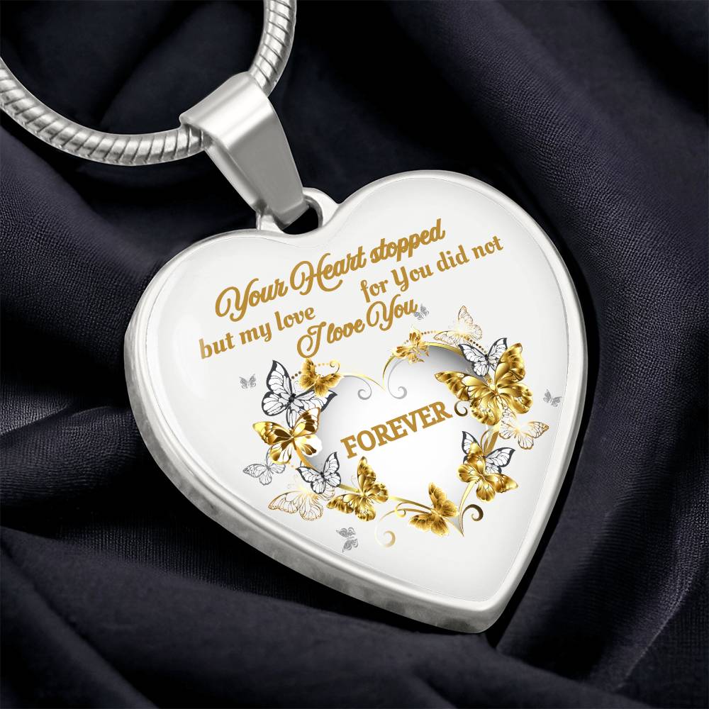 Silver heart-shaped pendant necklace with gold floral and butterfly accents and engraved sentimental message.