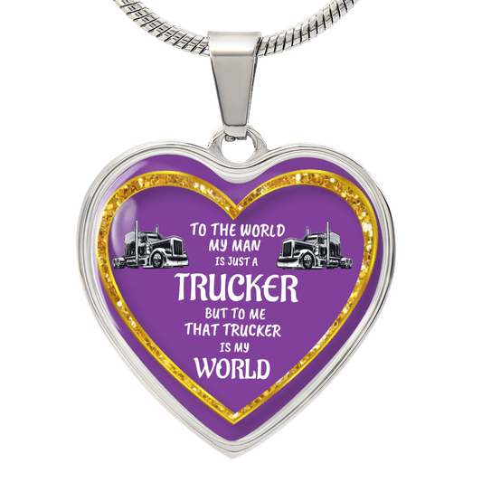 Heart-shaped pendant with a silver border, a gold glitter accent, and a purple background featuring two trucks and the text "To the world my man is just a trucker but to me that trucker is my world" on a silver chain.