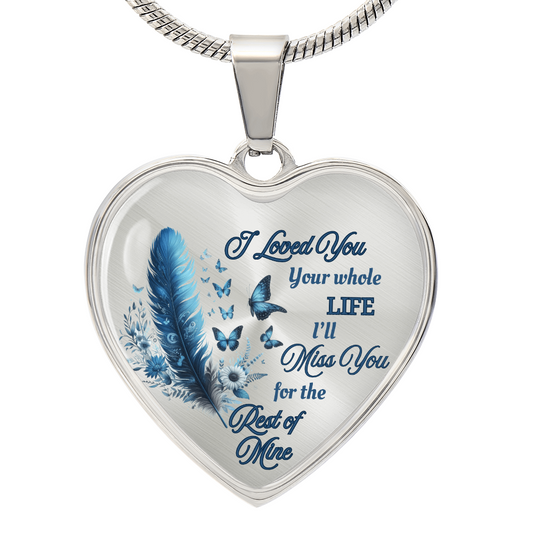 Silver heart-shaped pendant necklace with blue feather and engraved sentimental message.