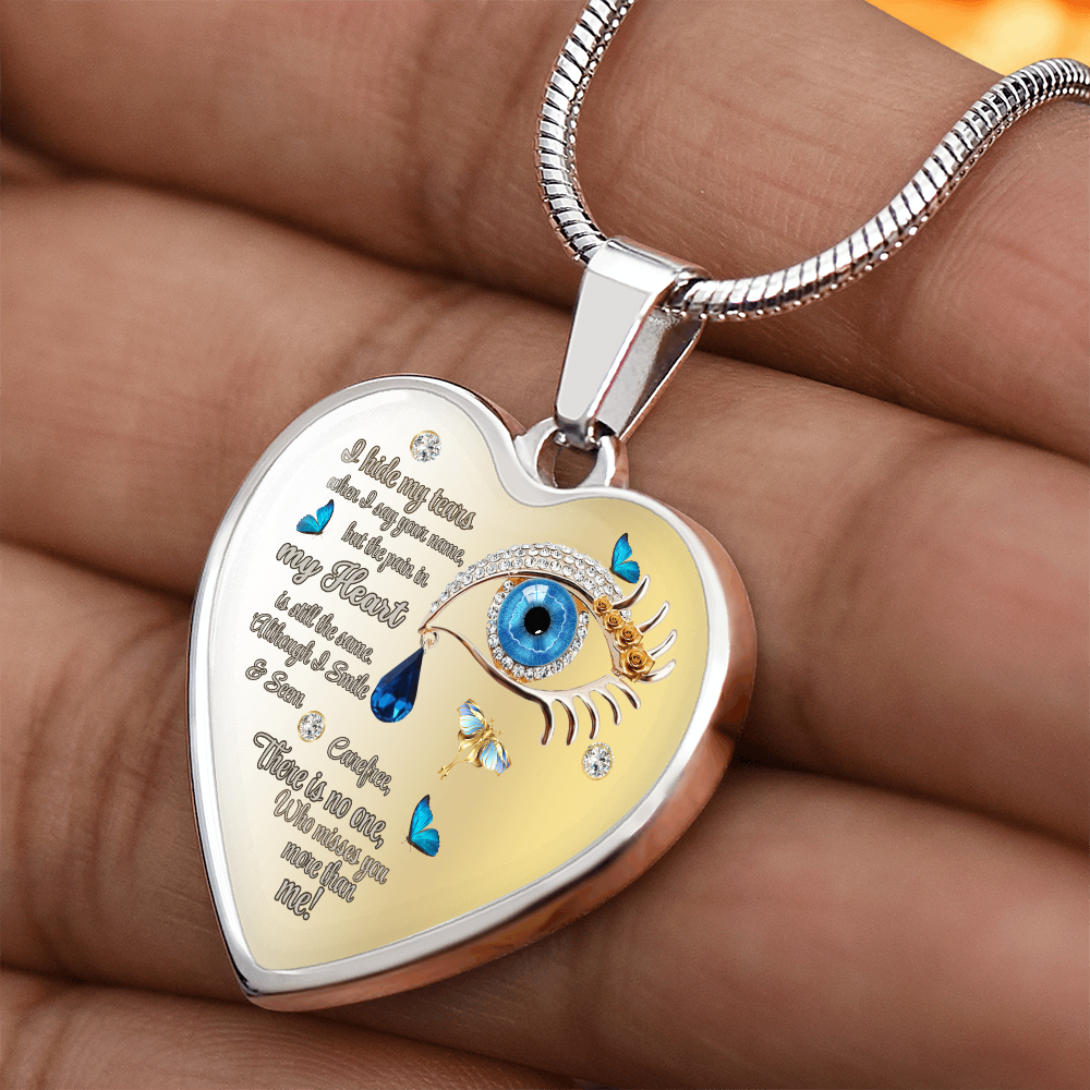 Silver heart-shaped necklace pendant with blue eye, tears, butterflies, and engraved poetic text.