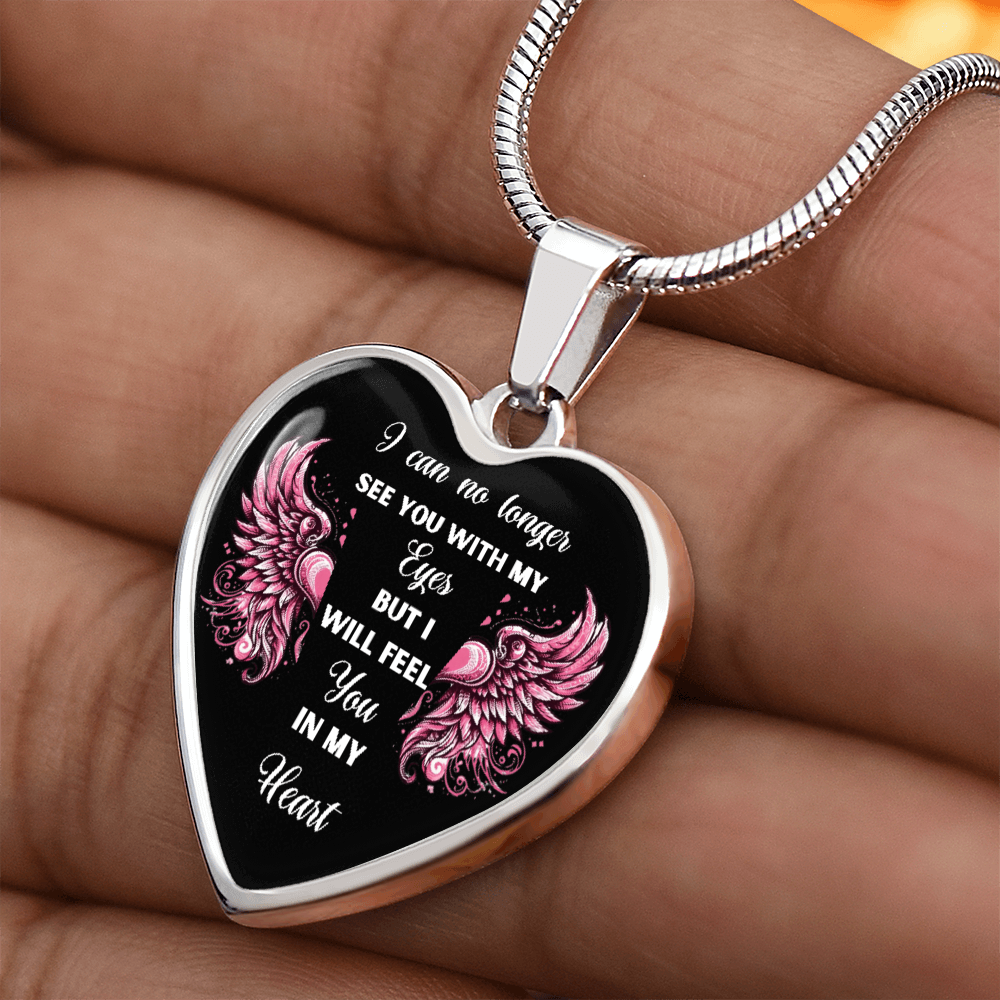 Silver heart-shaped pendant necklace with pink angel wings and sentimental white text on a black background.