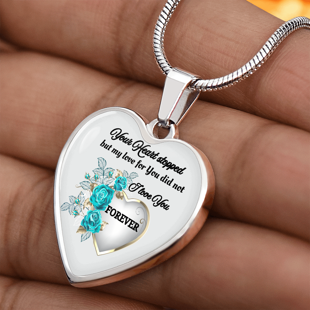 Silver heart-shaped pendant necklace with engraved sentimental message and blue floral design.