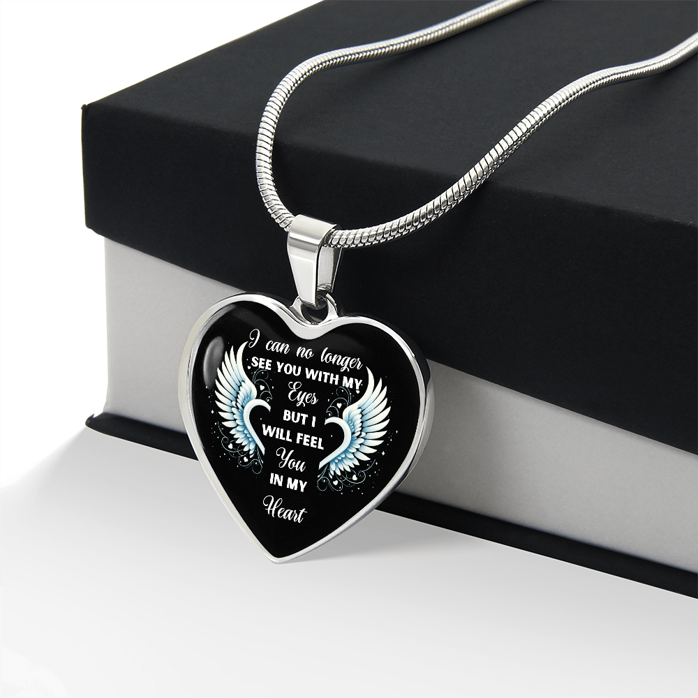 Heart-shaped pendant necklace with angel wings design and inscription, silver chain, displayed on black and white gift box.