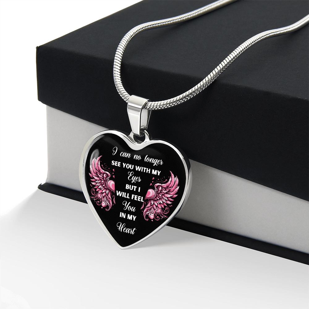 Silver heart-shaped pendant necklace with pink angel wings and engraved memorial message on black background.