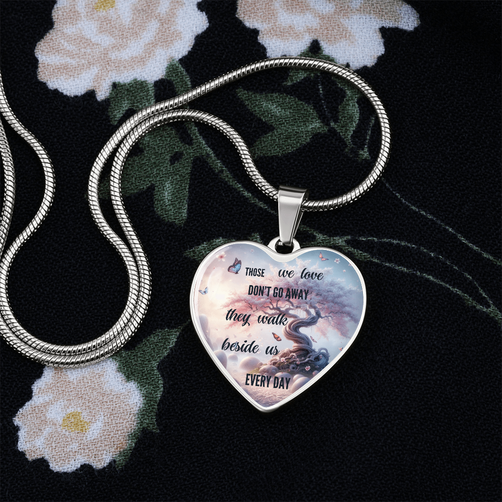 Silver heart-shaped pendant necklace with inscription and cloud background on a chain.