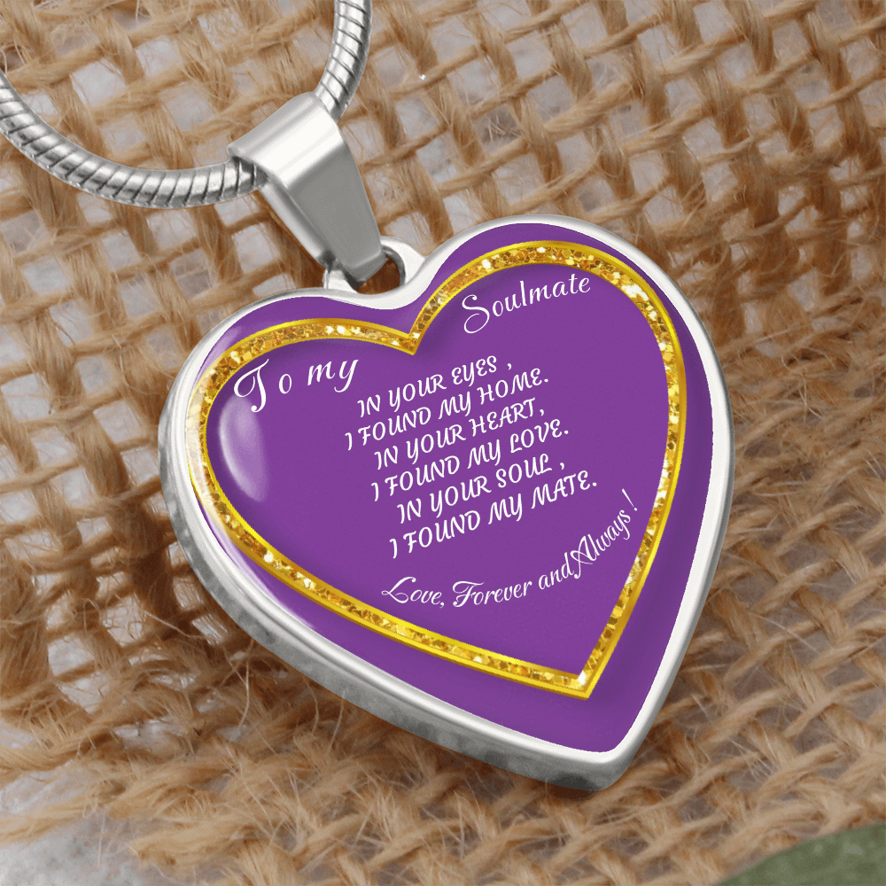 Heart-shaped pendant with a silver chain and a purple center with gold glitter accents, displaying the message "To my Soulmate, In your eyes, I found my home. In your heart, I found my love. In your soul, I found my mate. Love, Forever and Always!" on a burlap background.
