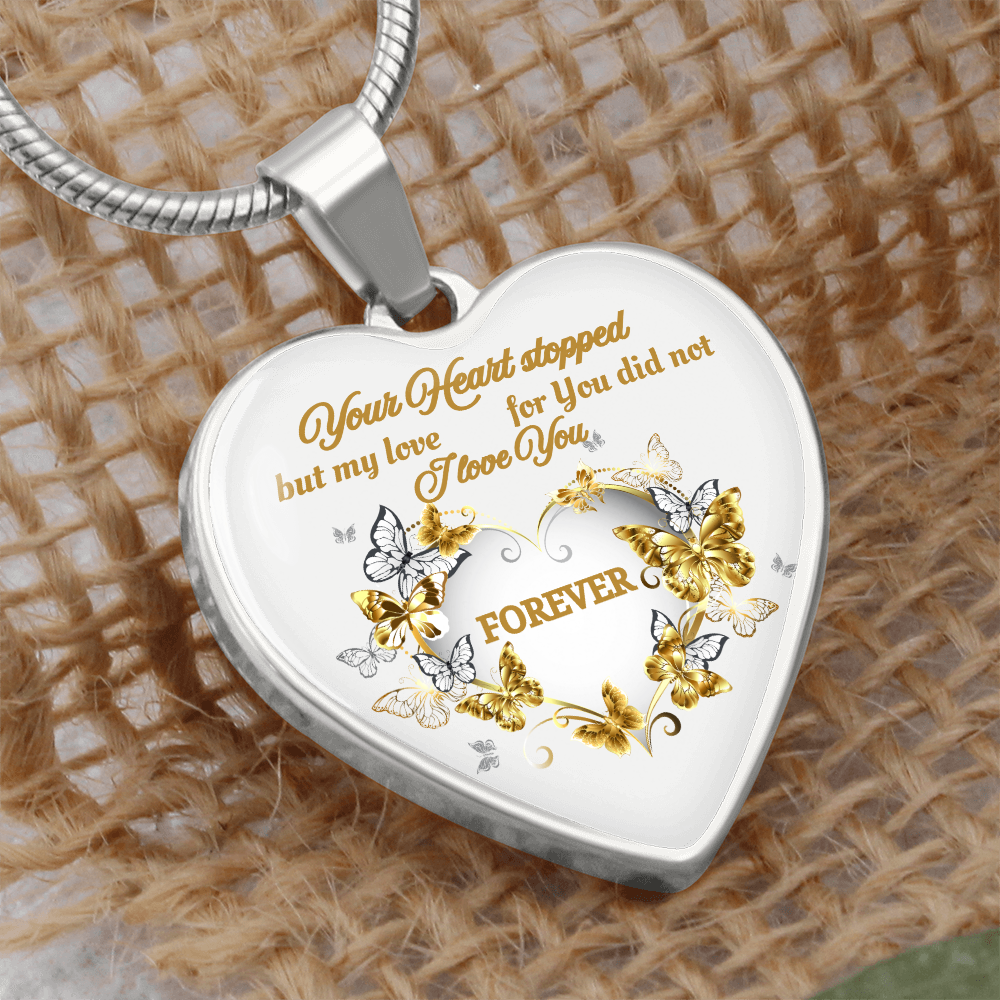 Silver heart pendant necklace with engraved gold and silver butterflies and the phrase "Your heart stopped, but my love for.