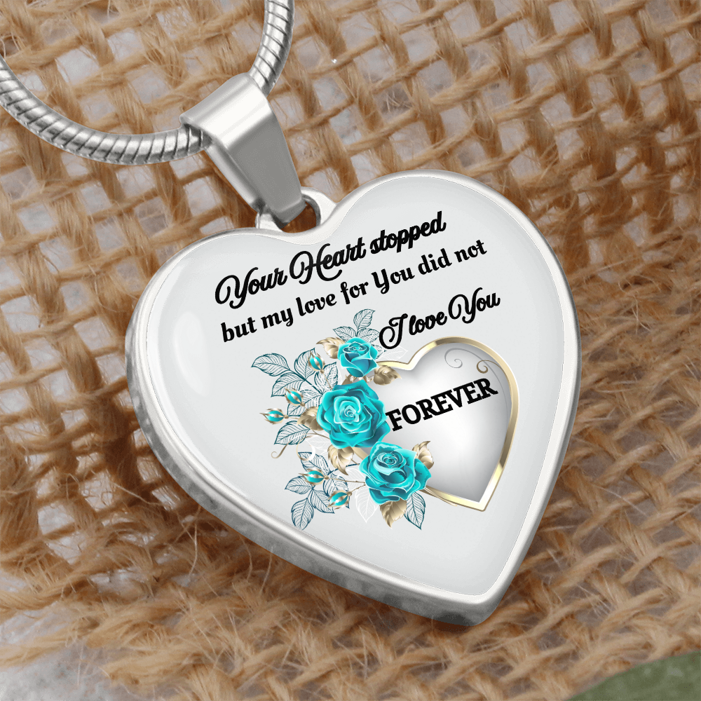 Silver heart-shaped pendant necklace with blue roses and engraved sentimental message.