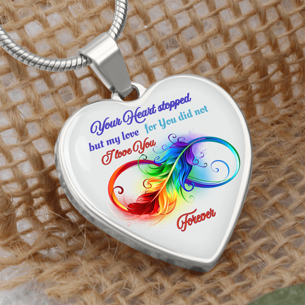 Silver heart-shaped pendant necklace with colorful feather and sentimental love quote engraving.