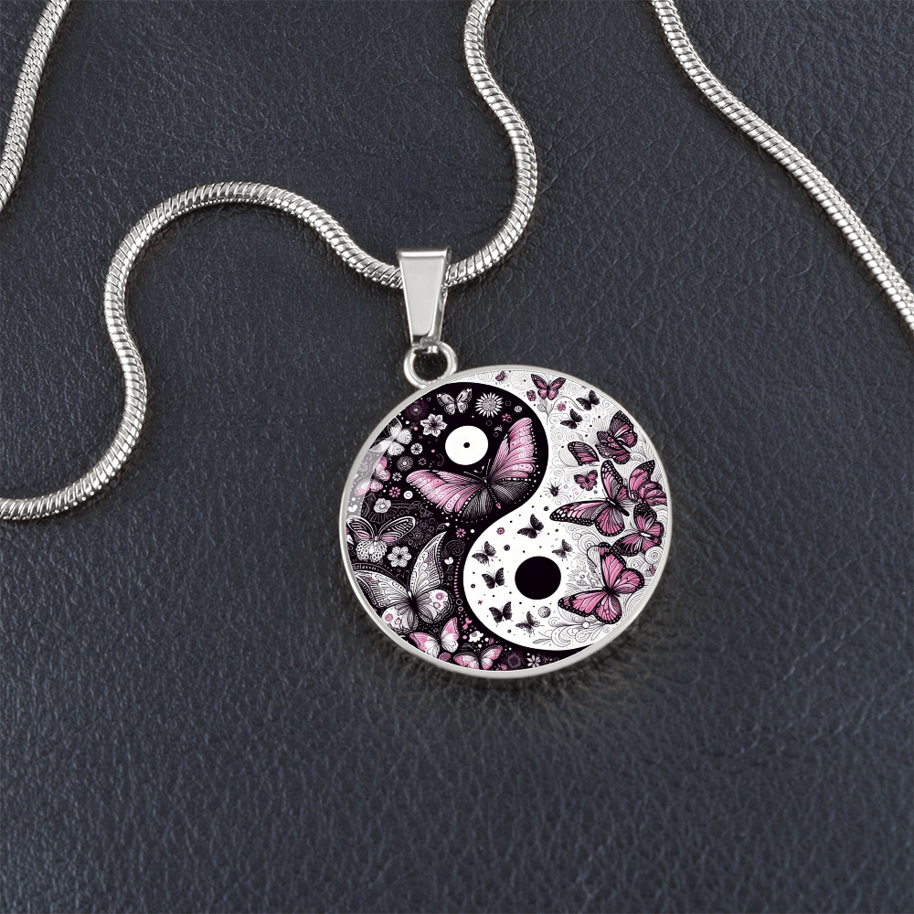 Silver circle pendant necklace featuring a yin yang design with pink and violet butterflies and floral details.