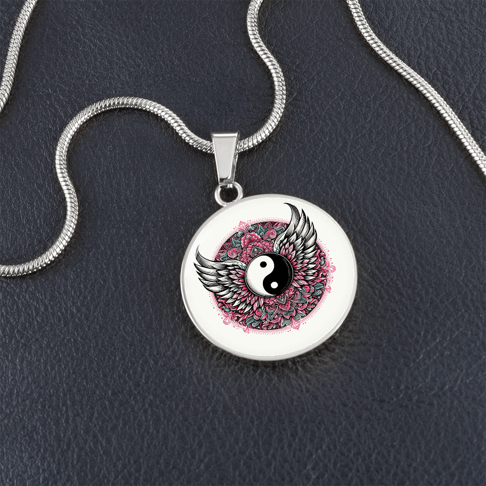 Silver circle necklace pendant featuring a black and white yin yang symbol with detailed angel wings and pink floral accents.