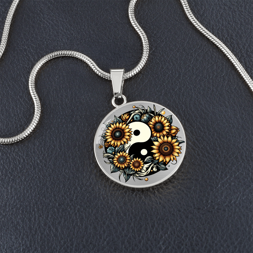 Silver circle necklace with yin yang symbol surrounded by sunflowers and floral details.