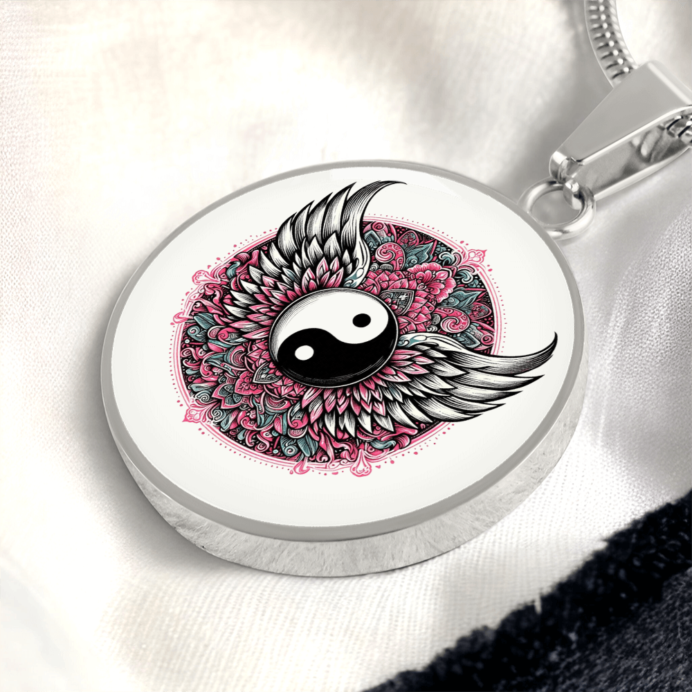 Silver circular pendant necklace featuring a yin yang symbol with detailed black and white angel wings over pink floral.