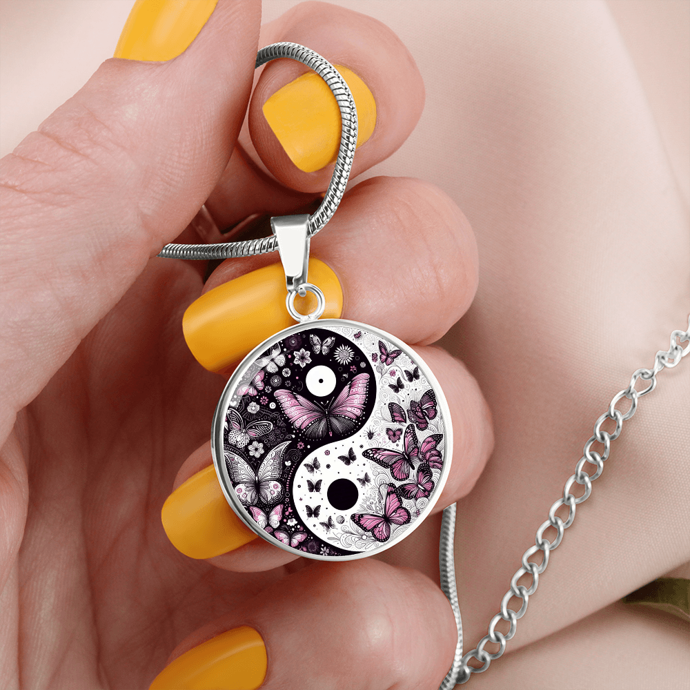 Silver circle pendant necklace with yin yang design and violet butterflies on a chain.