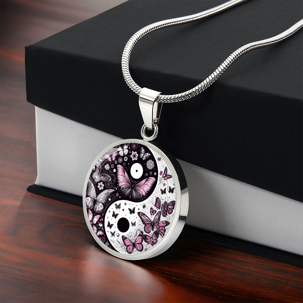 Silver circular necklace pendant featuring a black and white yin yang design adorned with violet butterflies and floral.
