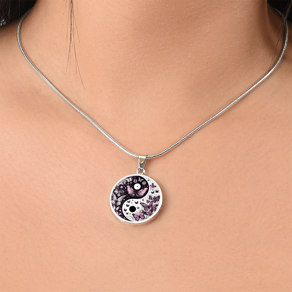Silver circle pendant necklace with black and white yin yang design and violet butterfly accents.