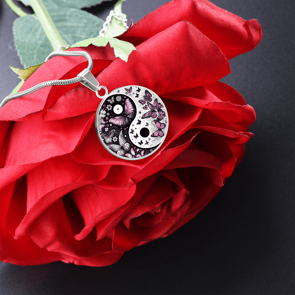 Silver circular yin yang necklace pendant with violet butterfly accents on red rose petals.