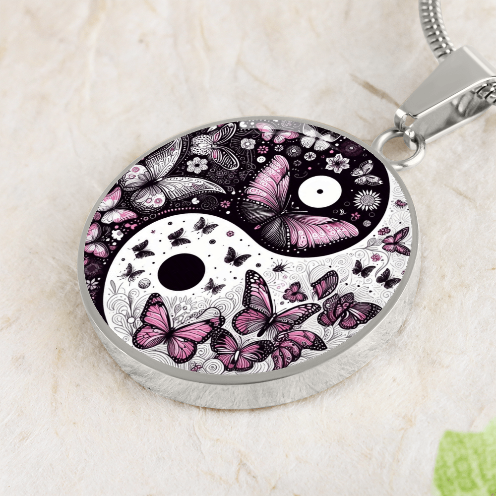 Silver circular pendant necklace with yin yang symbol, decorated with violet butterflies and floral patterns.