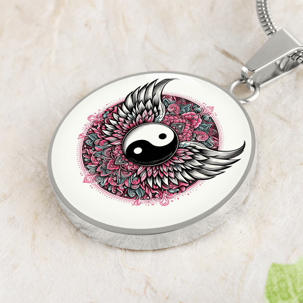 Silver circular necklace pendant with yin yang symbol, angel wings, and pink floral mandala design.