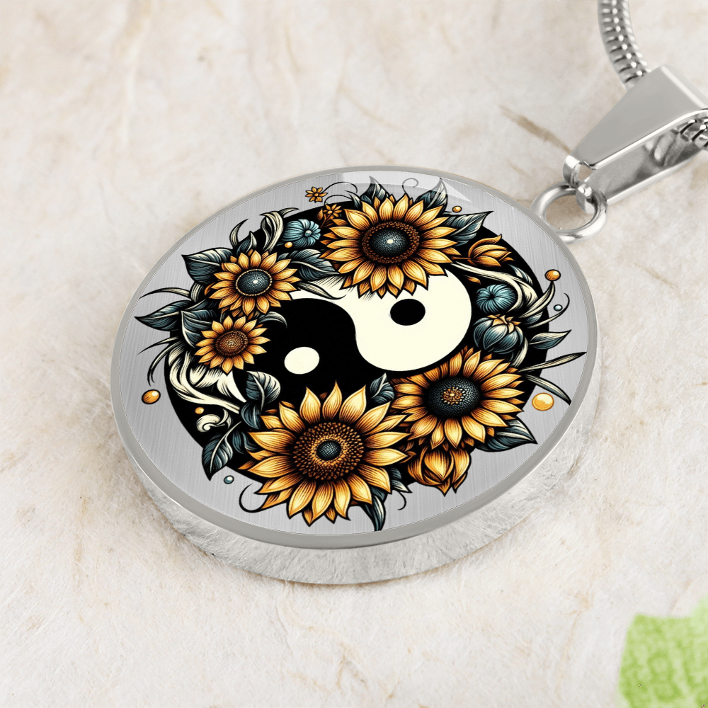 Silver round pendant necklace with yin yang symbol surrounded by detailed sunflowers and green leaves.