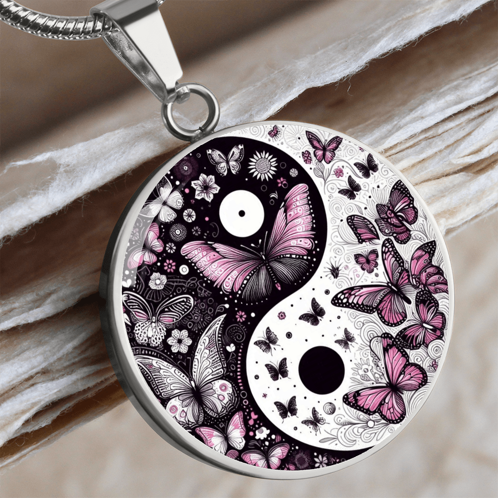 Silver yin yang necklace pendant with violet butterflies and floral accents on a curved chain.