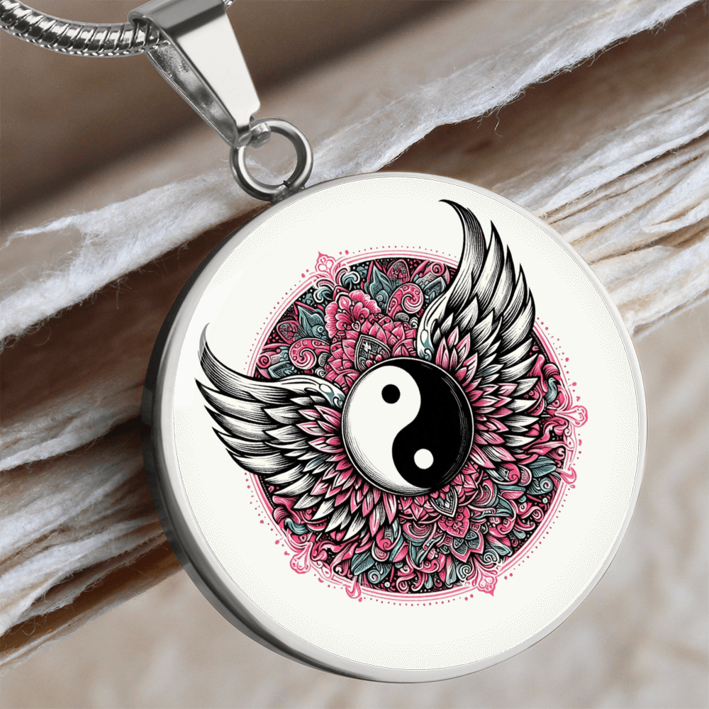 Silver circular pendant necklace featuring a yin yang symbol with detailed angel wings and a pink floral mandala background.