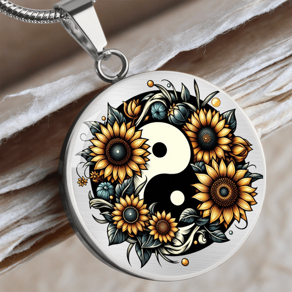 Silver circle necklace pendant with a black and white yin yang symbol surrounded by vibrant sunflowers and green leaves.