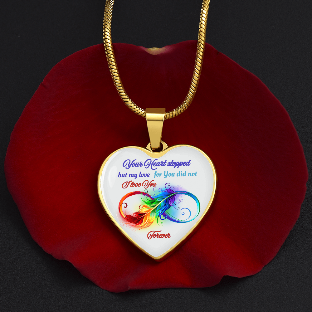 Gold heart pendant necklace with colorful butterfly and inscription on white background.