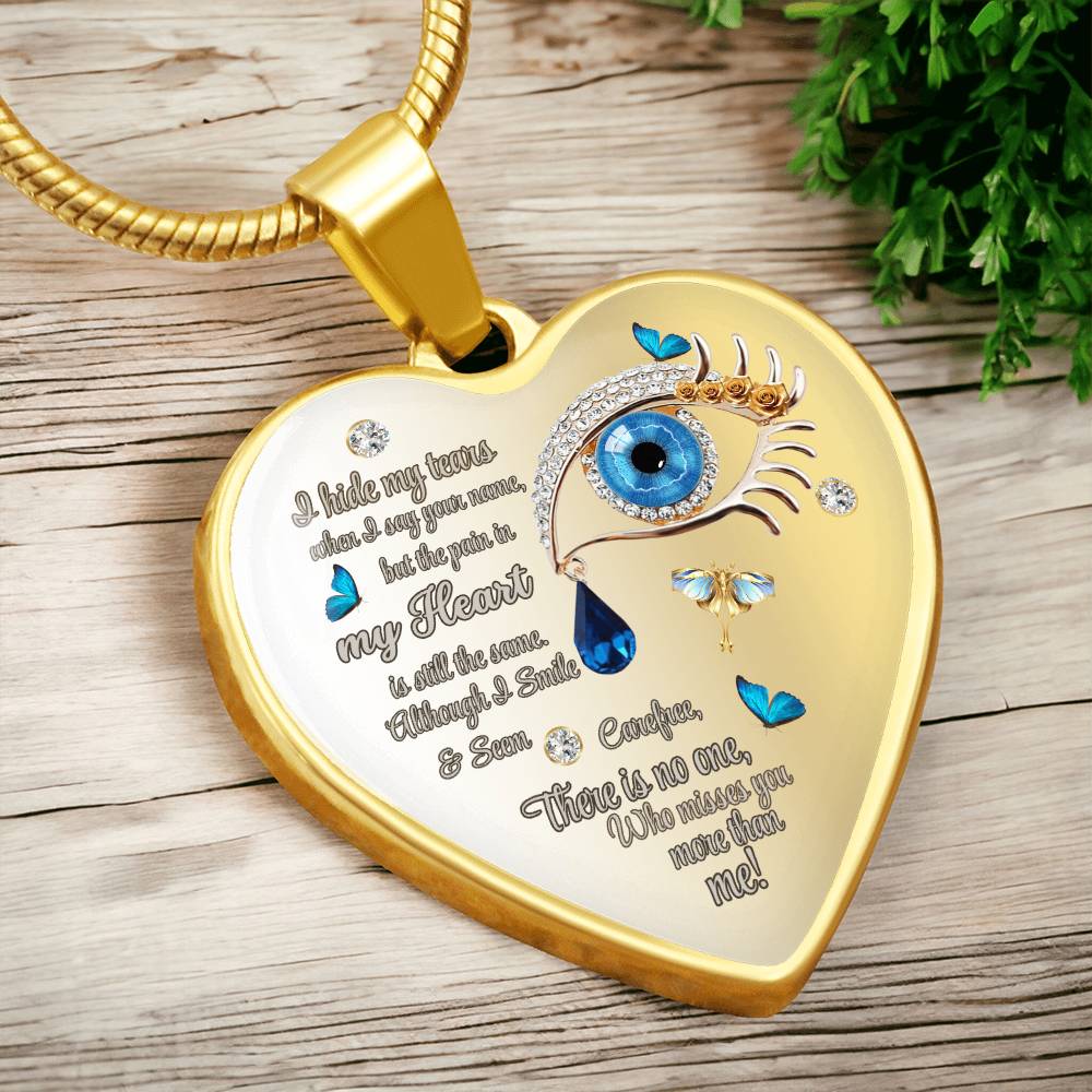 Gold heart-shaped necklace pendant with blue eye, teardrops, butterflies, and engraved sentimental text.