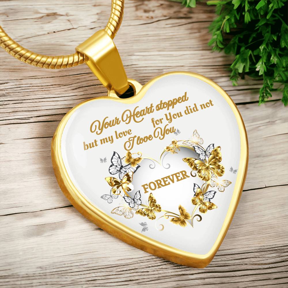 Gold heart-shaped pendant necklace with engraved sentimental message and butterfly detailing.