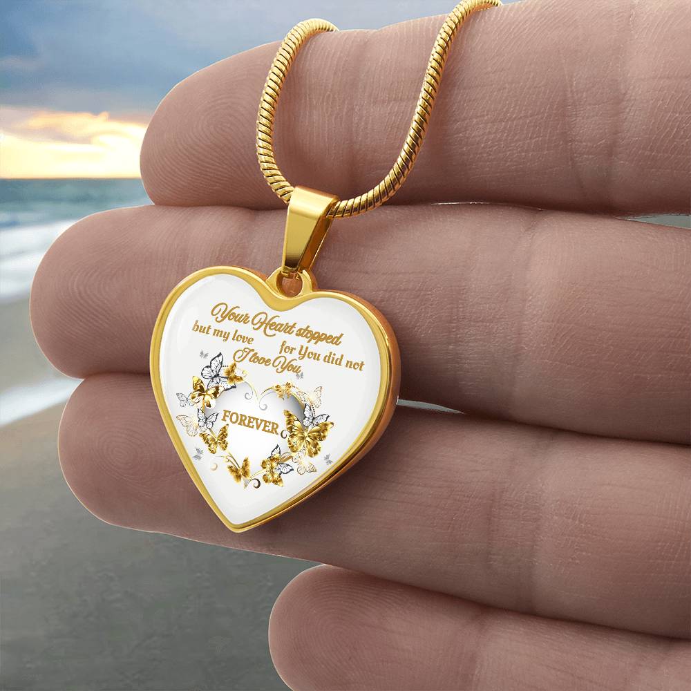 Gold heart pendant necklace with engraved floral design and sentimental message on white background.
