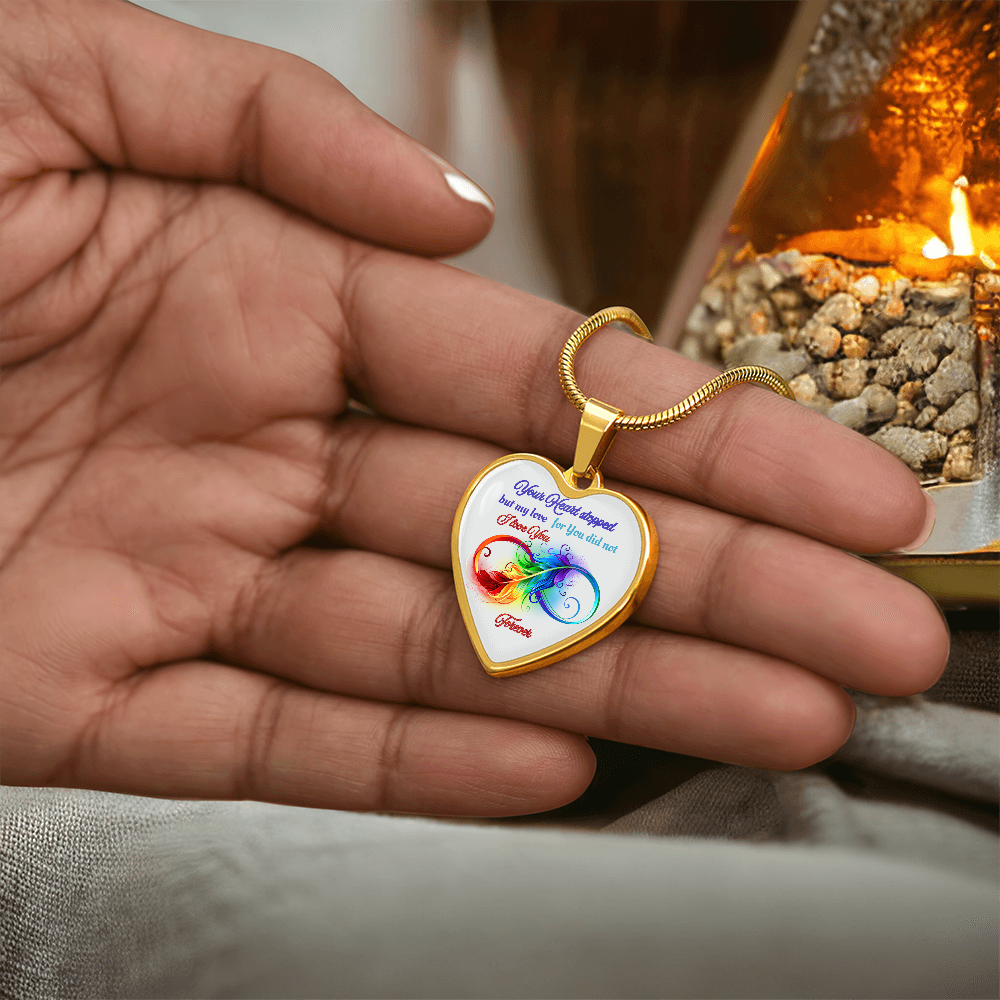 Gold heart-shaped pendant with colorful infinity and love quote on delicate chain.