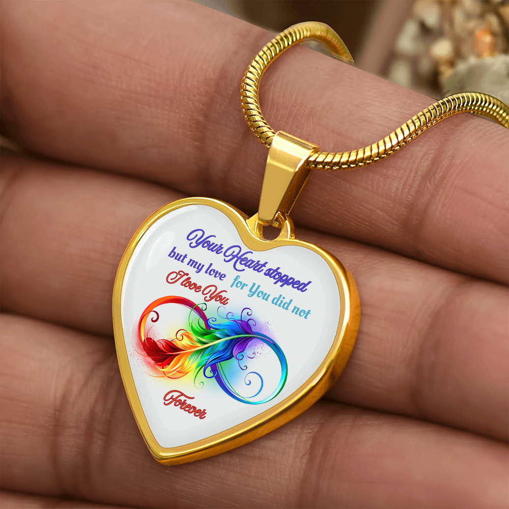 Gold heart-shaped pendant necklace with colorful feather design and sentimental text engraving.