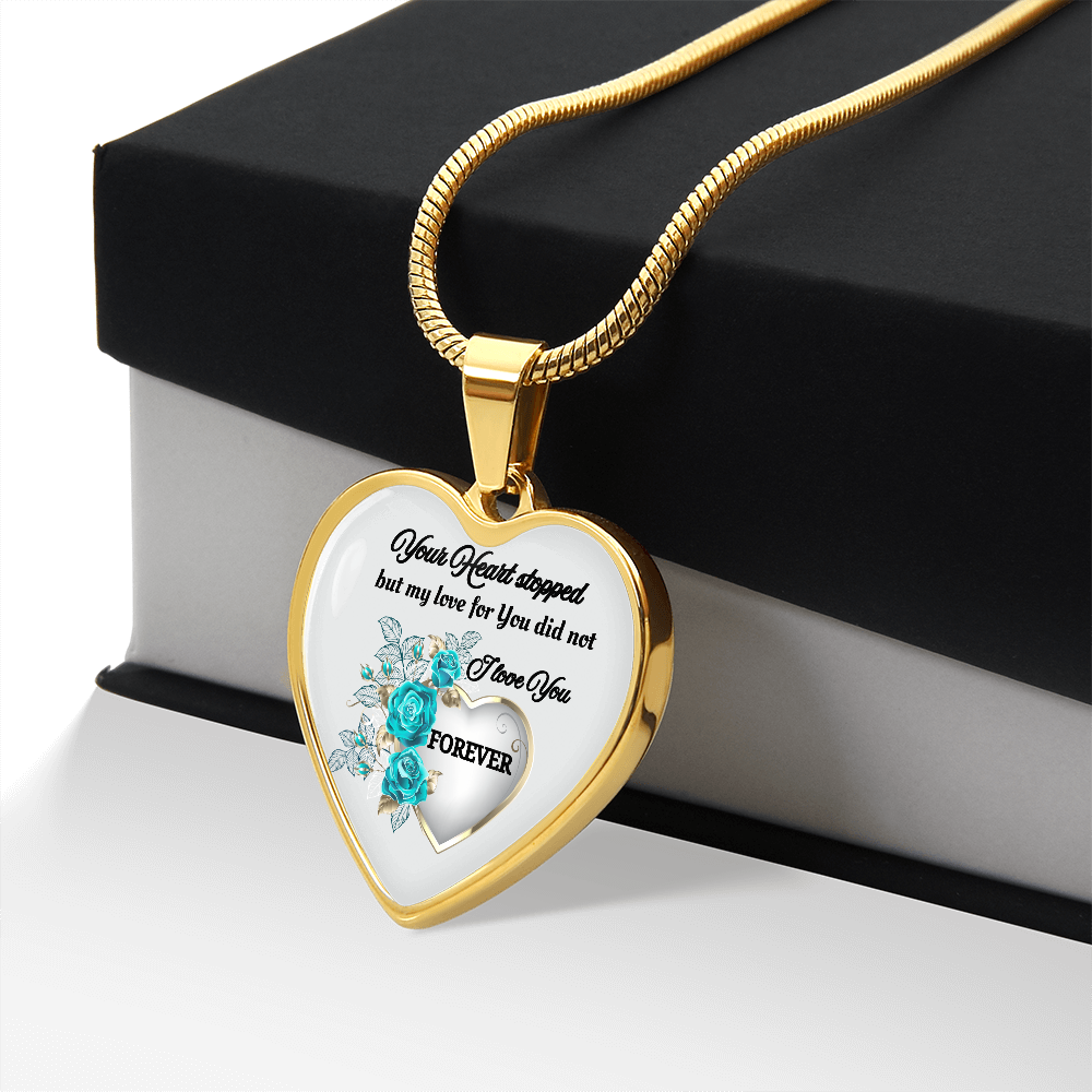 Gold heart-shaped pendant necklace with memorial message and blue floral ribbon design on white background.