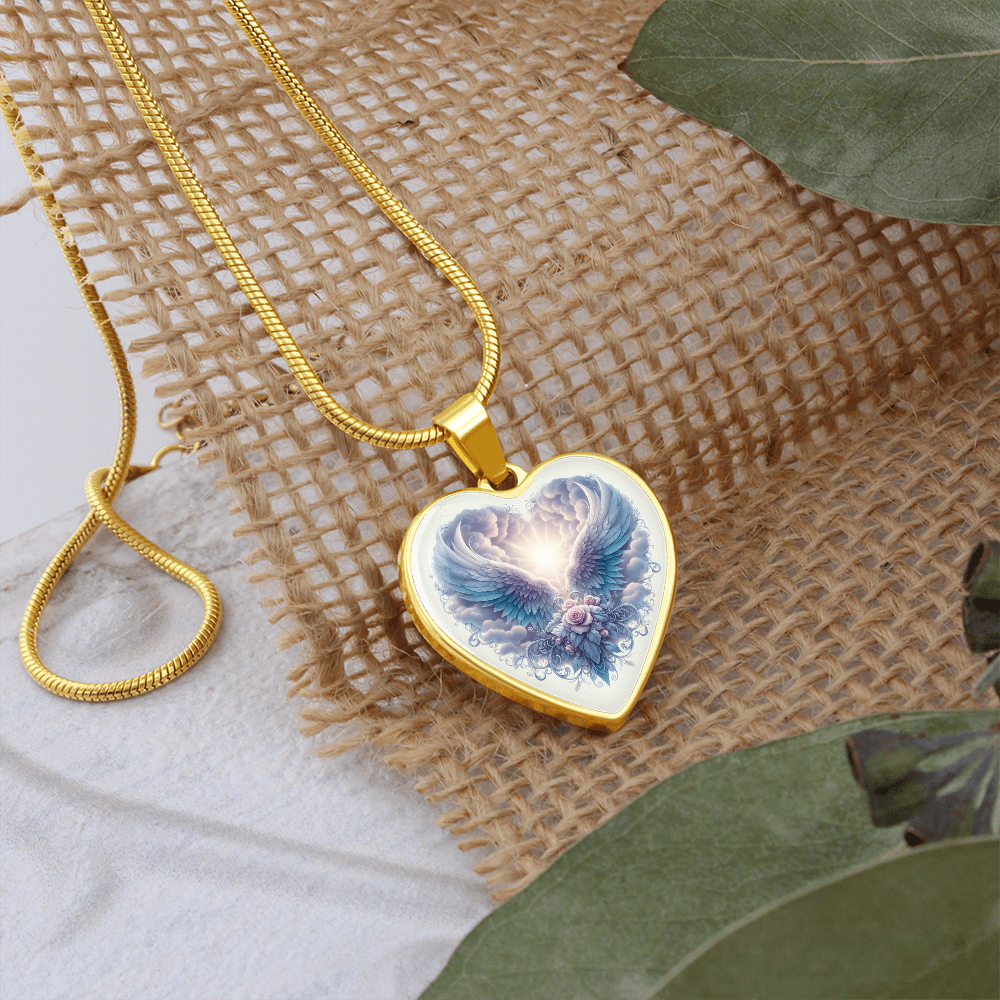 Gold heart pendant necklace with angel wings graphic on a fine chain.