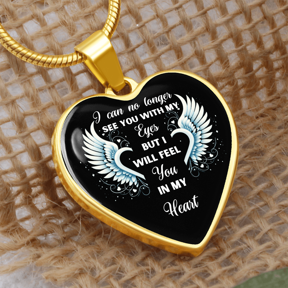 Gold heart-shaped necklace pendant with white angel wings and sentimental text on black background.