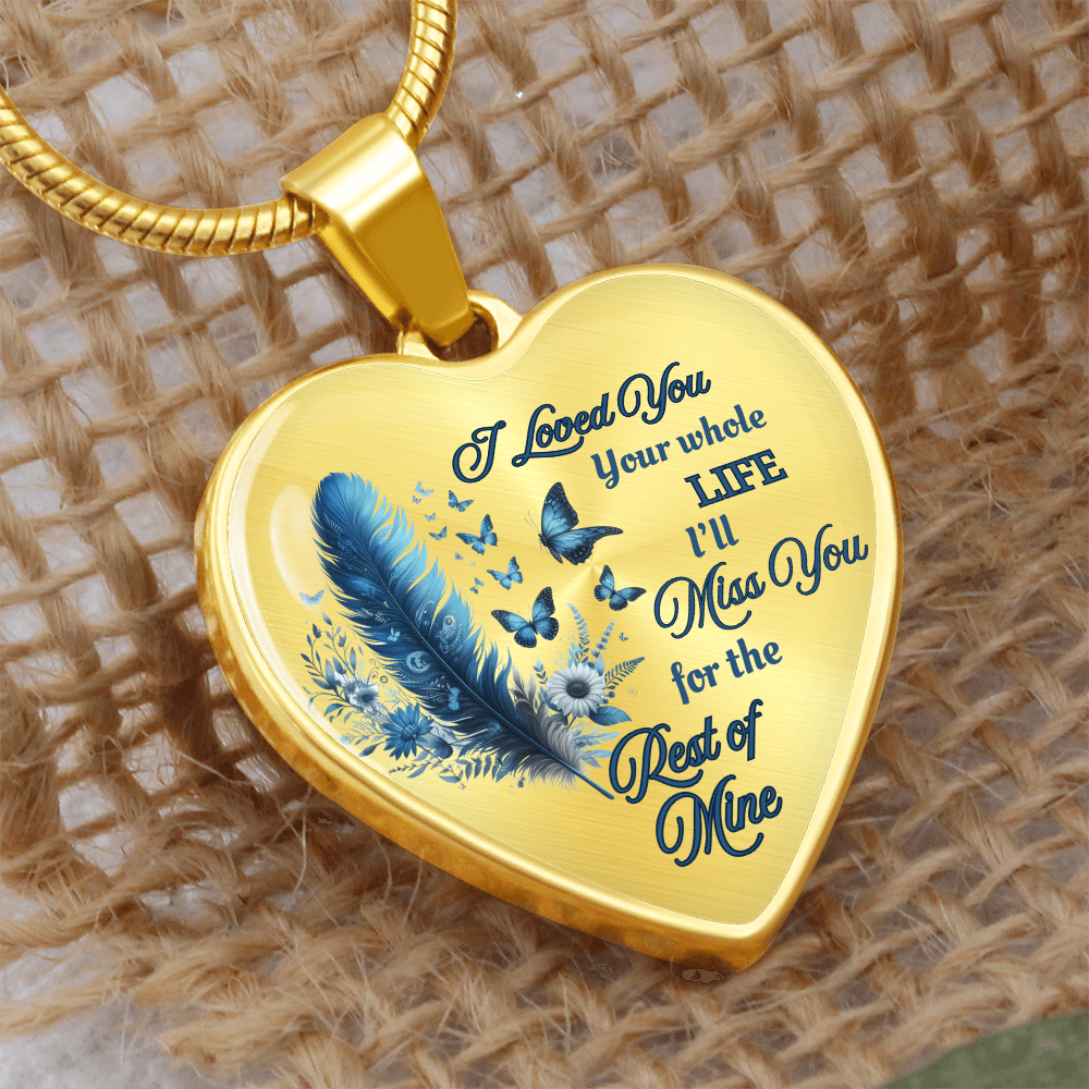 Gold heart-shaped pendant with blue feather and butterfly design, engraved sentimental message.