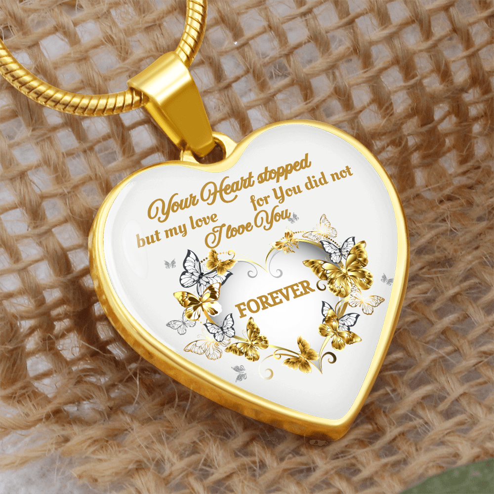 Gold heart pendant necklace with engraved sentimental message and butterfly accents on white background.