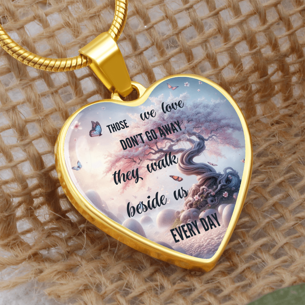Gold heart-shaped pendant necklace with a sentimental tree and cloud design, inscribed with "Those we love don't go away.